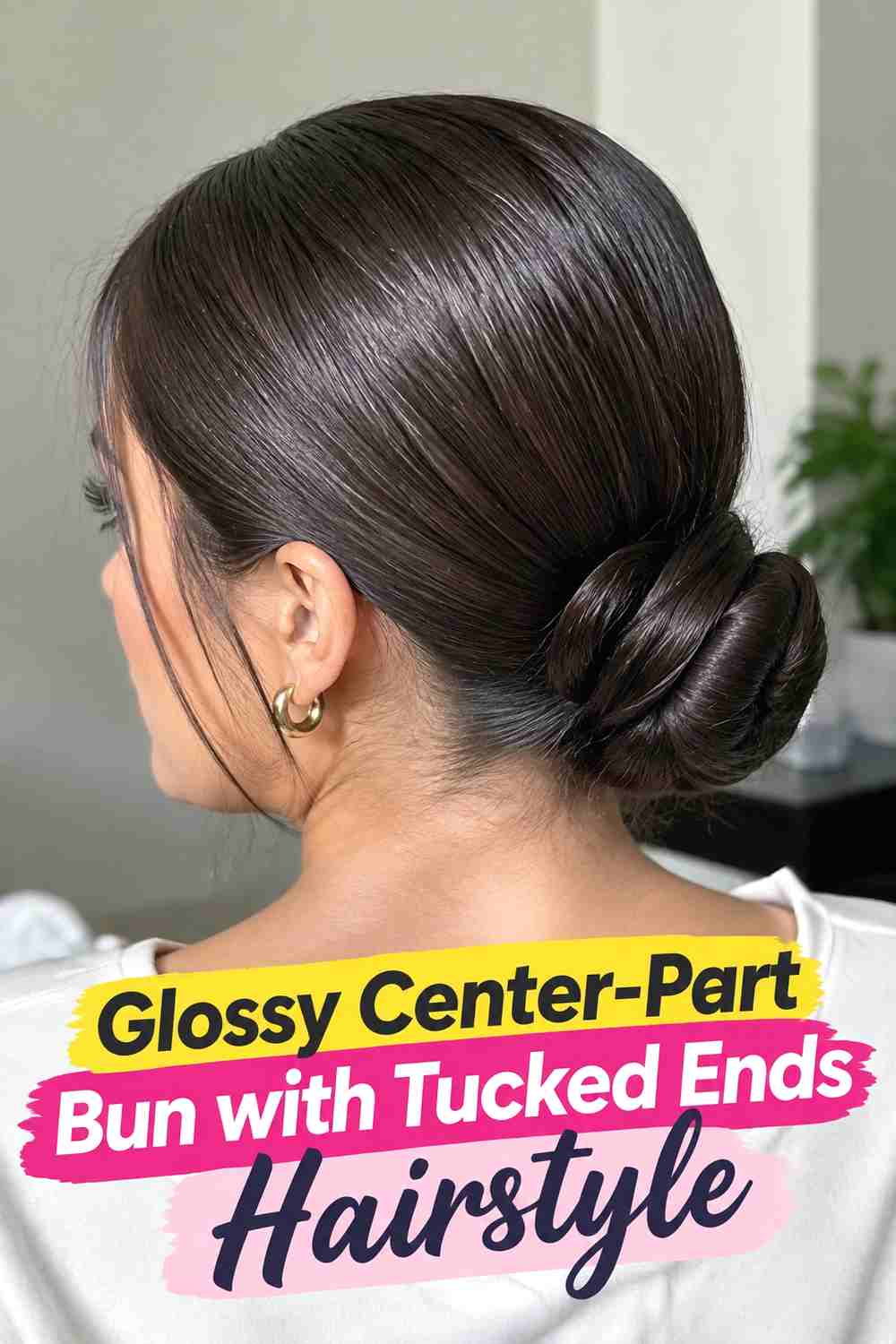9. Glossy Center Part Bun With Tucked Ends Hairstyle