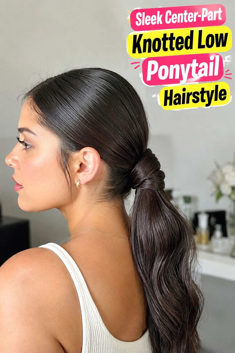2. Sleek Center Part Knotted Low Ponytail Hairstyle