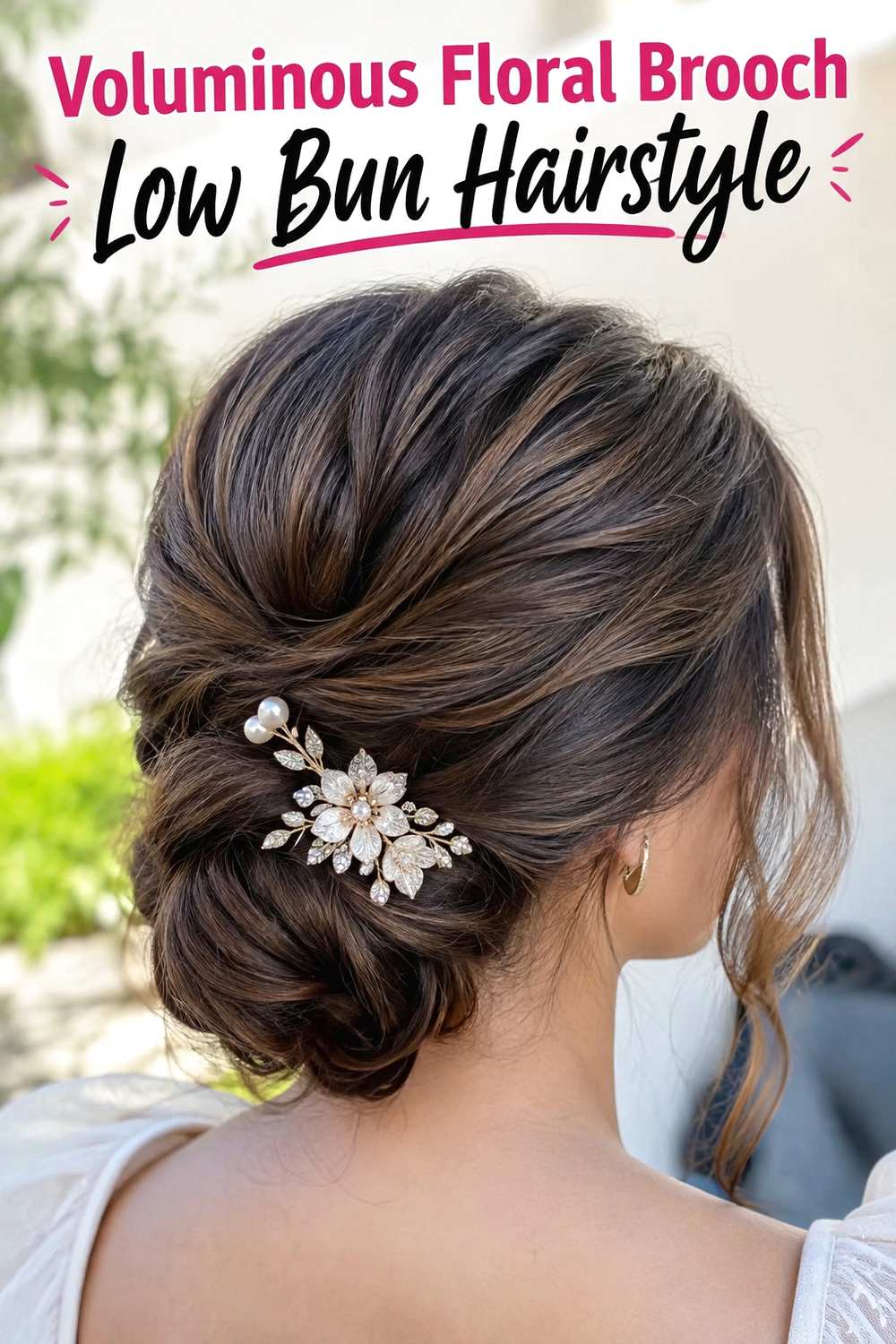 13. Voluminous Floral Brooch Low Bun Hairstyle