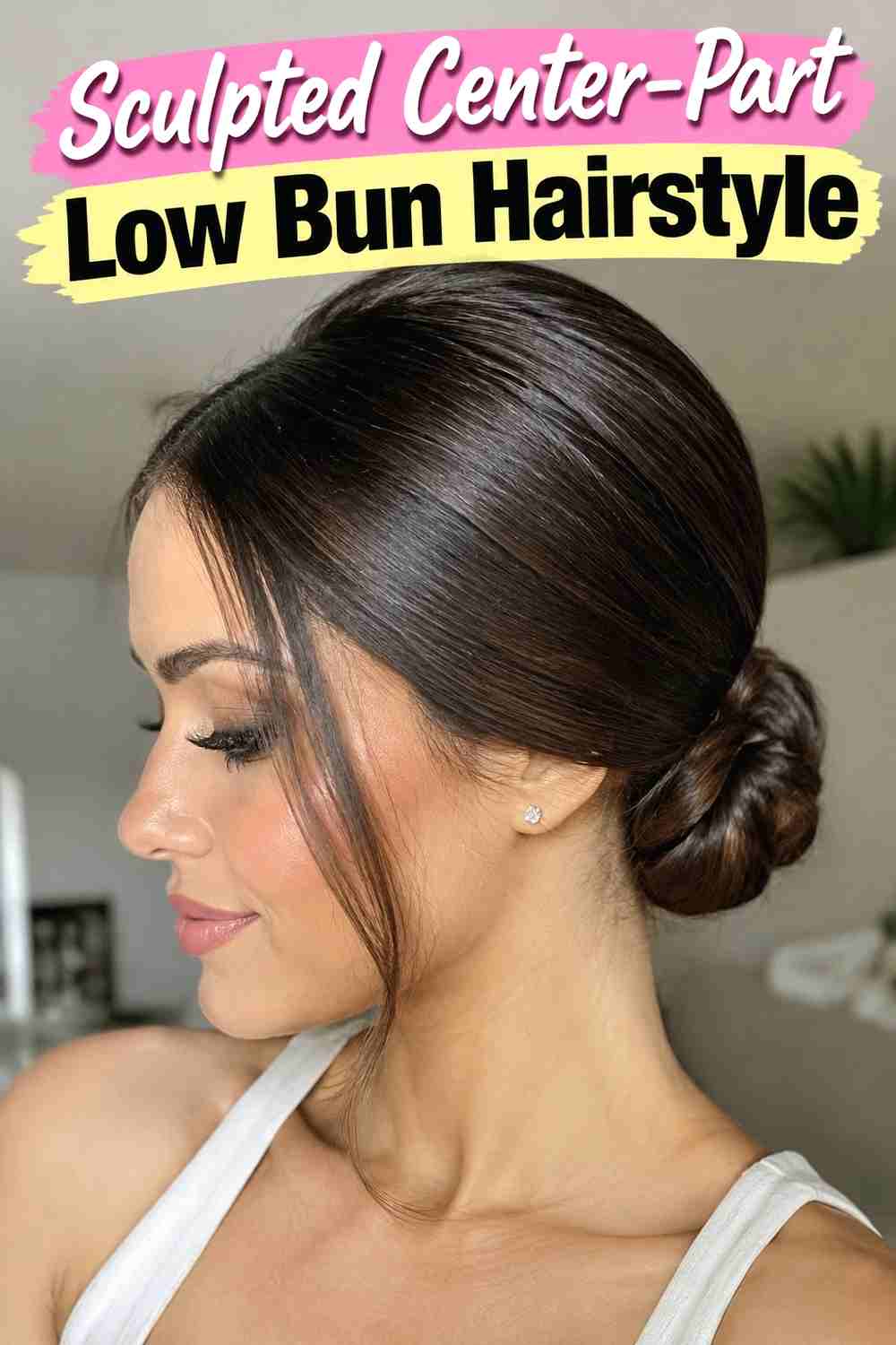 1. Sculpted Center Part Low Bun Hairstyle